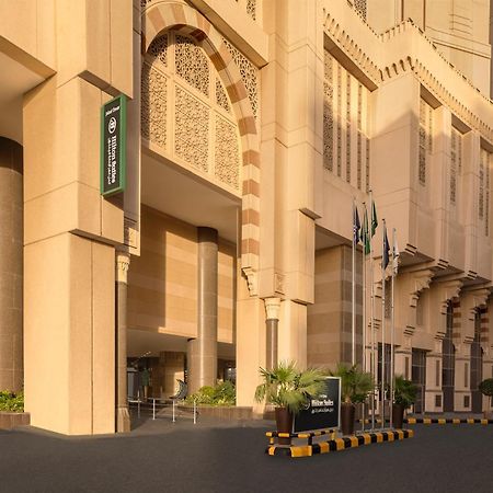 Hilton Suites Jabal Omar Makkah Mecca Exterior photo The photo shows a modern building with a distinctive architectural style, featuring large, light-colored stone facades. The entrance is prominent, with a wide, inviting pathway leading up to it. To the left, there is a sign that appears to indicate t